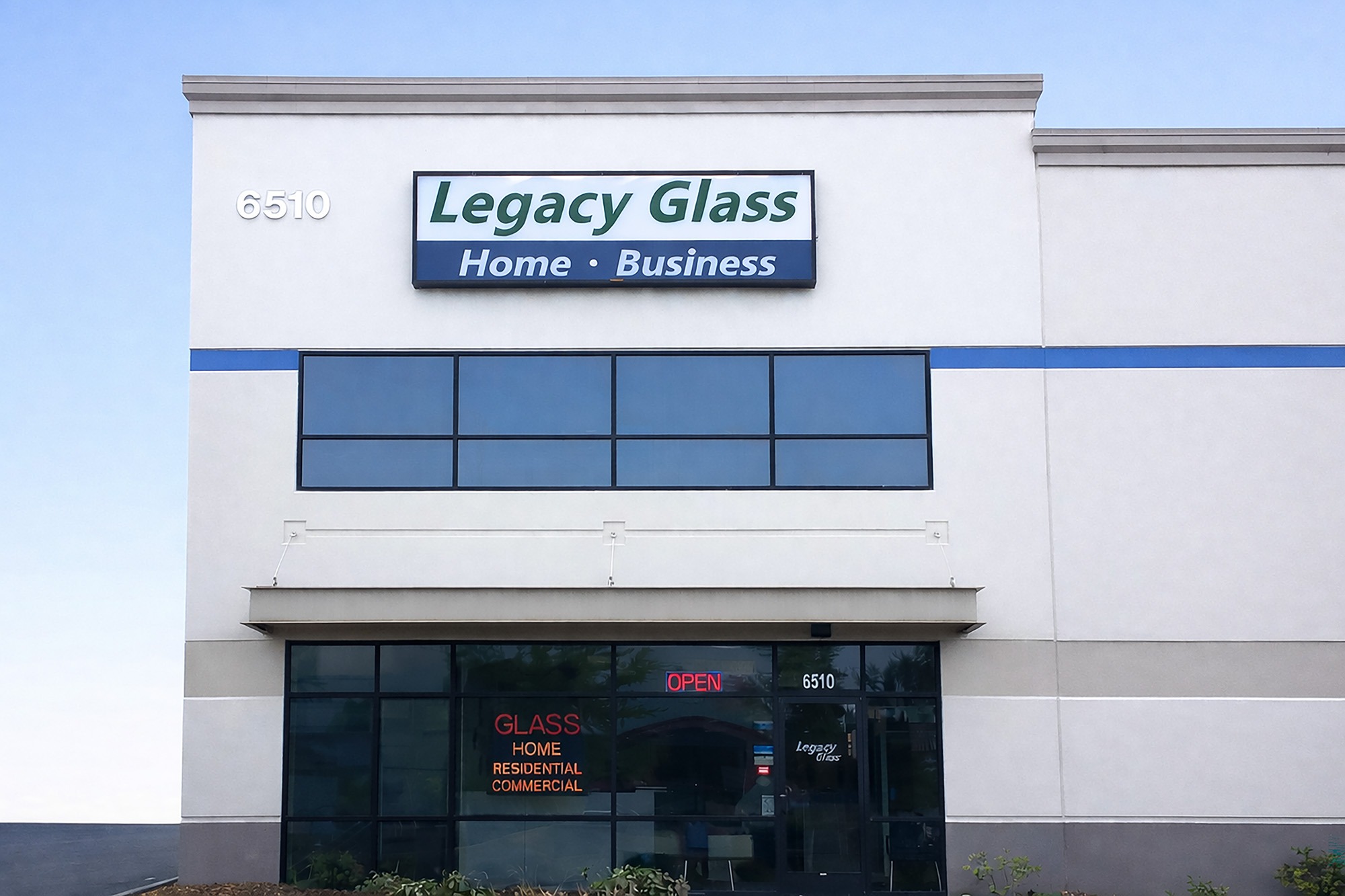 Signage for Legacy Glass, featuring "Home • Business." The storefront is open, advertising services for residential and commercial glass needs.