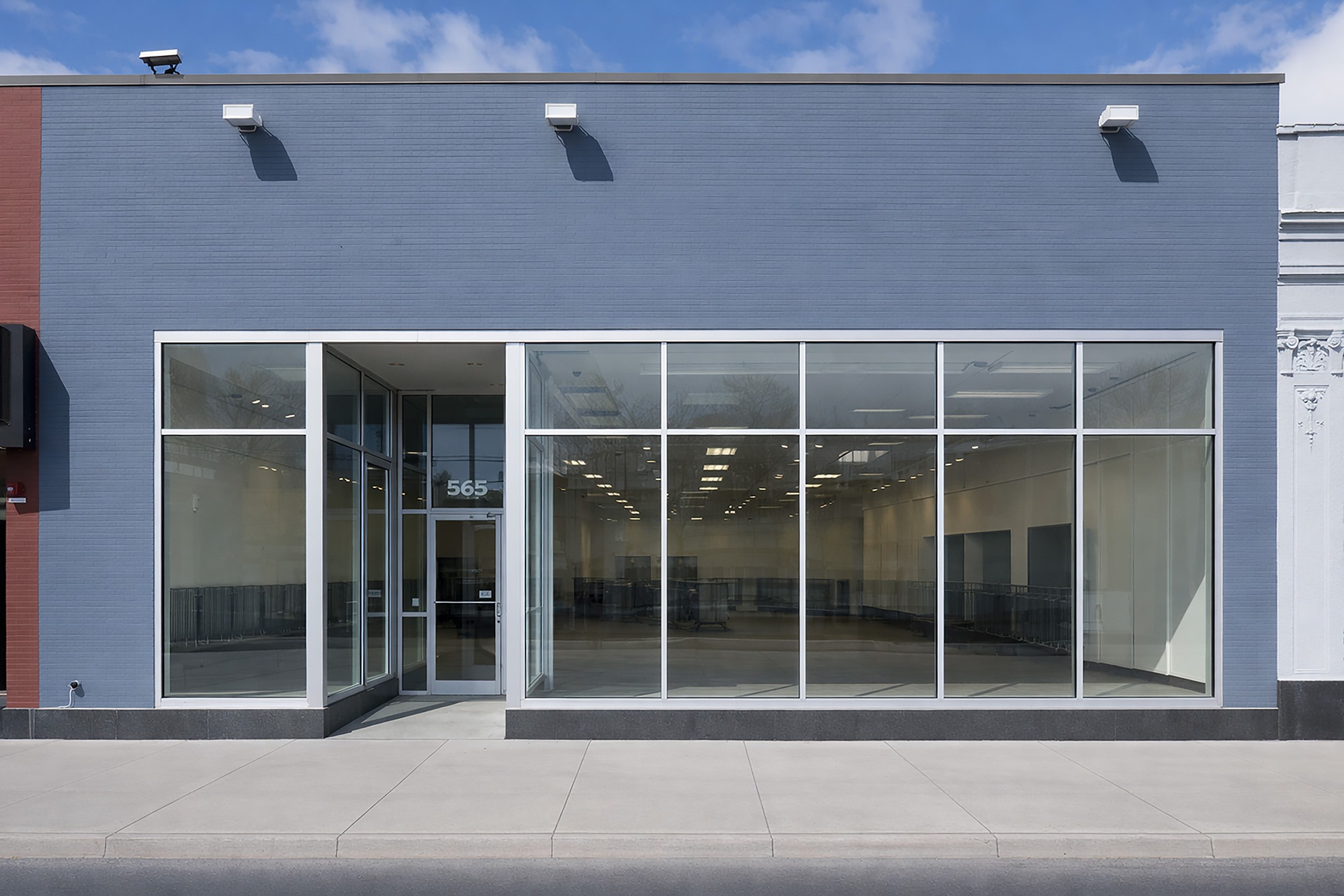 Storefront with large windows, featuring an empty interior space. The building is designed for retail use, highlighting an inviting entrance.
